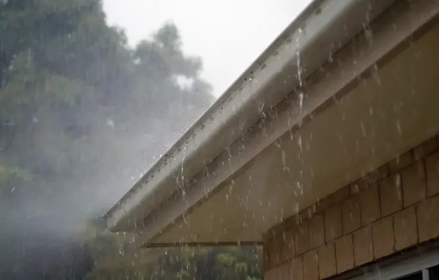 Rain pouring off a roof gutter